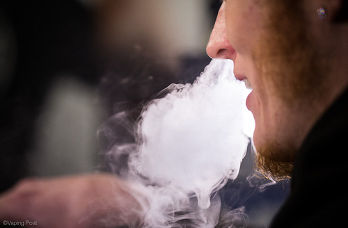 Vaper blowing cloud utilizing e-cigarette